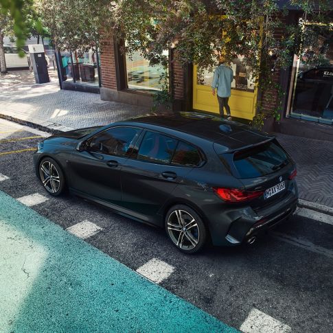 BMW M135i xDrive, odparkované. BMW M135i xDrive v metalickej farbe Black Sapphire, odparkované, pohľad z vtáčej perspektívny na bočnú časť.