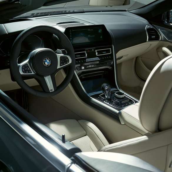 BMW M850i xDrive Cabrio, kokpit. BMW M850i xDrive Cabrio v metalickej farbe Dravit Grey s otvorenou strechou, kokpit s M koženým volantom.