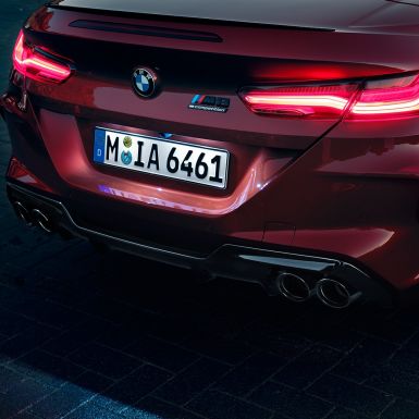 BMW M8 Competition Cabrio, detailný pohľad na zadnú časť. BMW M8 Competition Cabrio v metalickej farbe Motegi Red, detailný pohľad na zadnú časť s LED zadnými svetlami a znakom M8 Competiton.