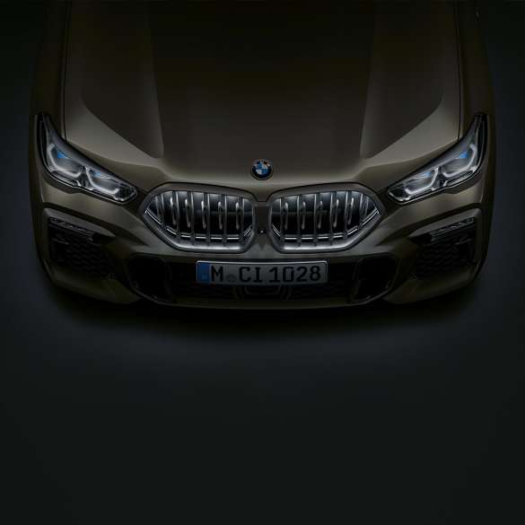 BMW X6 predná časť. Detailný pohľad na prednú časť BMW X6 s BMW mriežkou chladiča Iconic Glow z vtáčej perspektívy.
