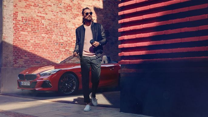 BMW Z4 Roadster v bočnej ulici Muž v bočnej ulici pred BMW Z4 Roadster