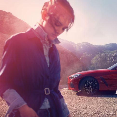 BMW Z4 Roadster s horami v pozadí Muž, žena a BMW Z4 Roadster s horami v pozadí
