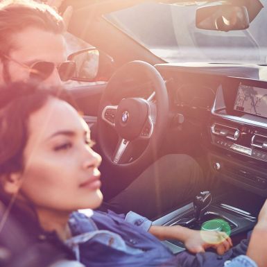 BMW Z4 Roadster so ženou a mužom Tmavovlasá žena a muž v BMW Z4 Roadster