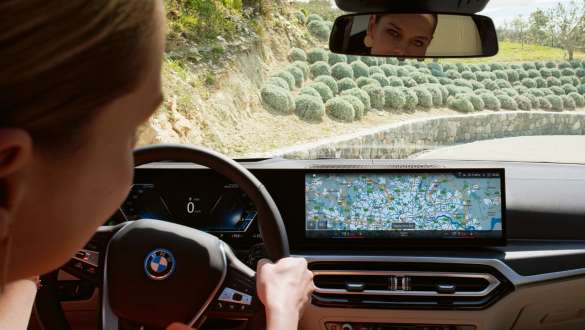 Osoba vo vozidle sa pozerá na BMW Curved Display Osoba vo vozidle sa pozerá na BMW Curved Display s navigáciou