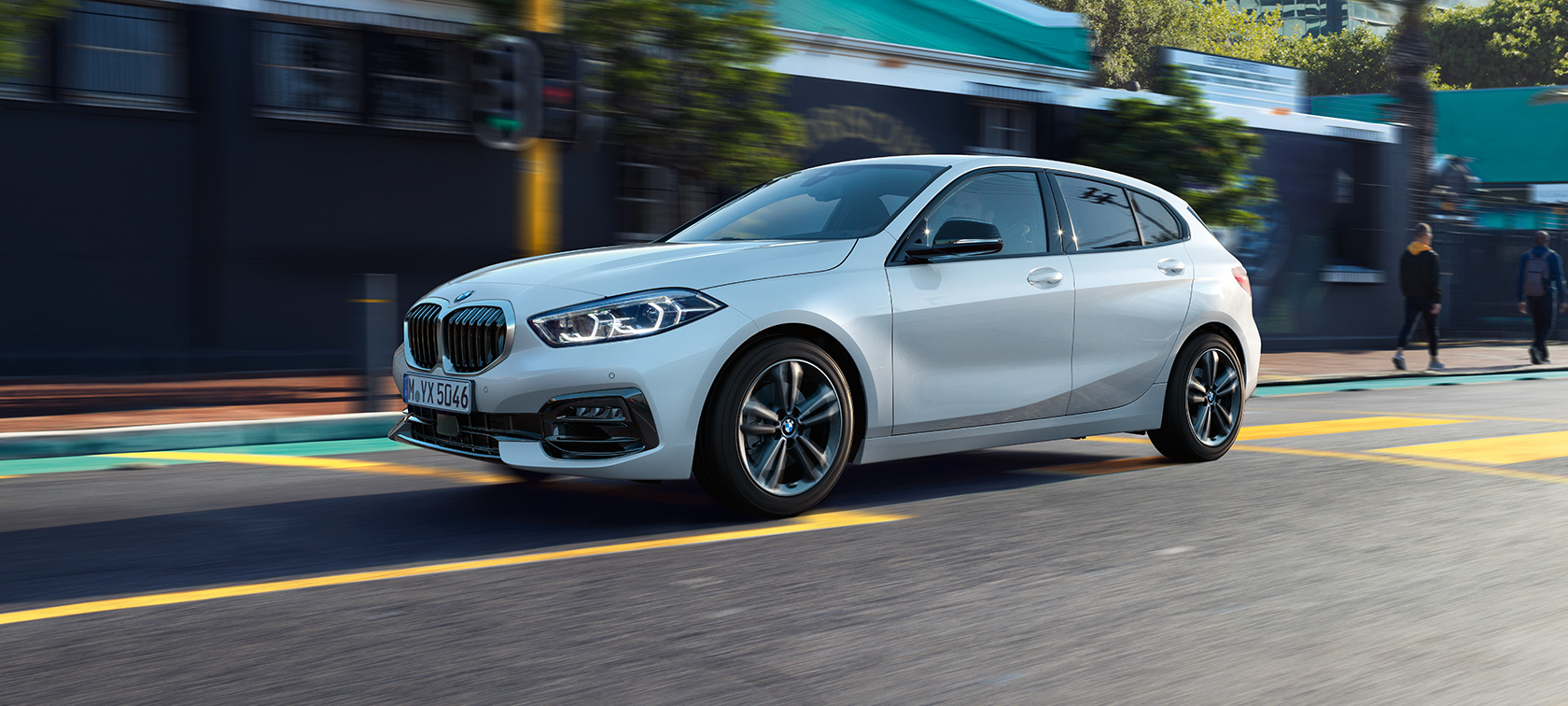 BMW radu 1 Model Sport Line, trojštvrťový bočný pohľad. BMW radu 1 Model Sport Line v metalickej farbe Mineral White, trojštvrťový bočný pohľad, jazda.