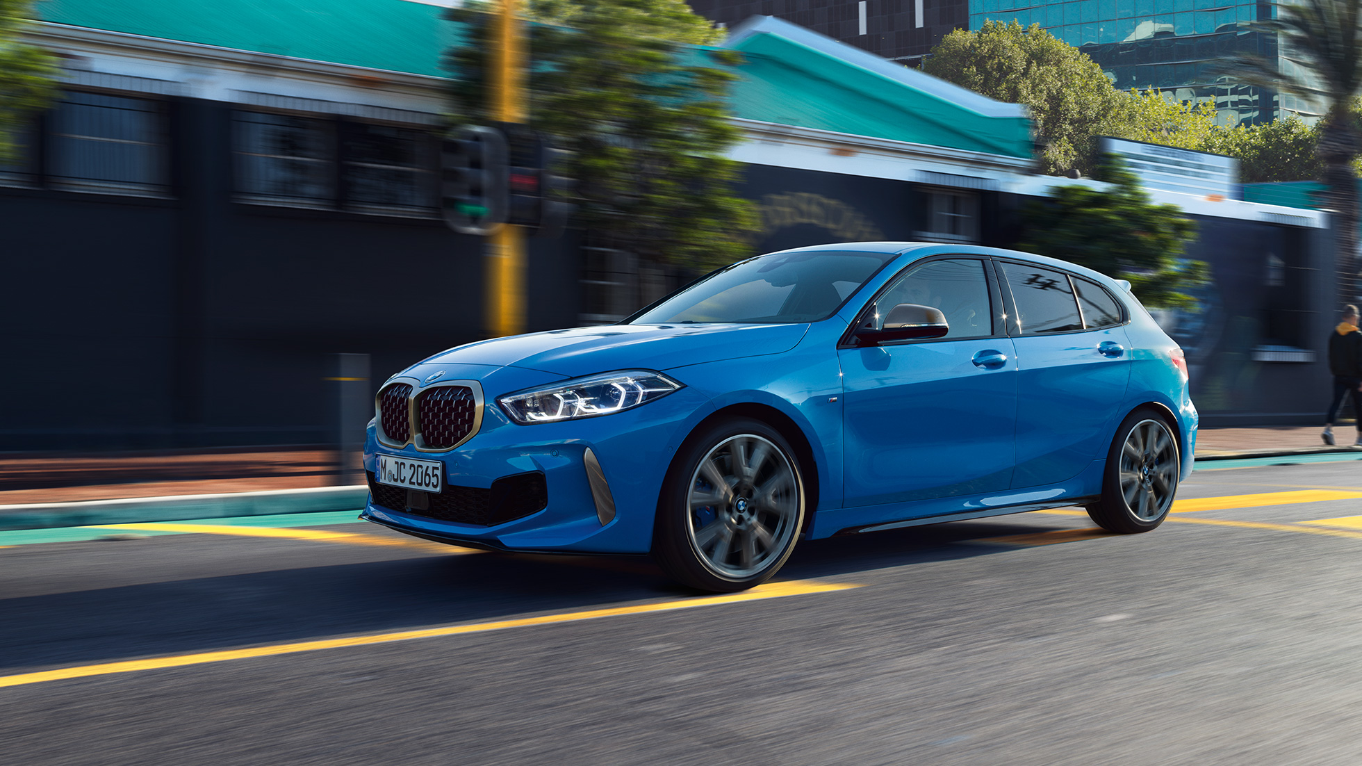 BMW radu 1, trojštvrťový bočný pohľad. BMW radu 1 v metalickej farbe Misano Blue, Silver, trojštvrťový predný pohľad počas jazdy.