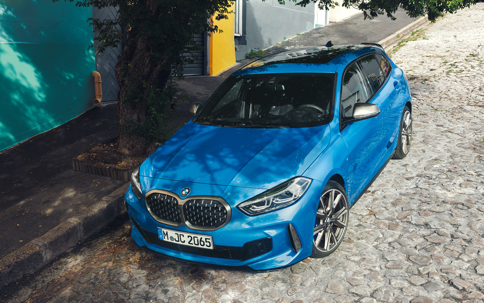 BMW radu 1 M135i F40 pri ceste BMW radu 1 M135i F40 metalíza Misano Blue, predobočný pohľad, parkovanie pri ceste, pohľad zhora
