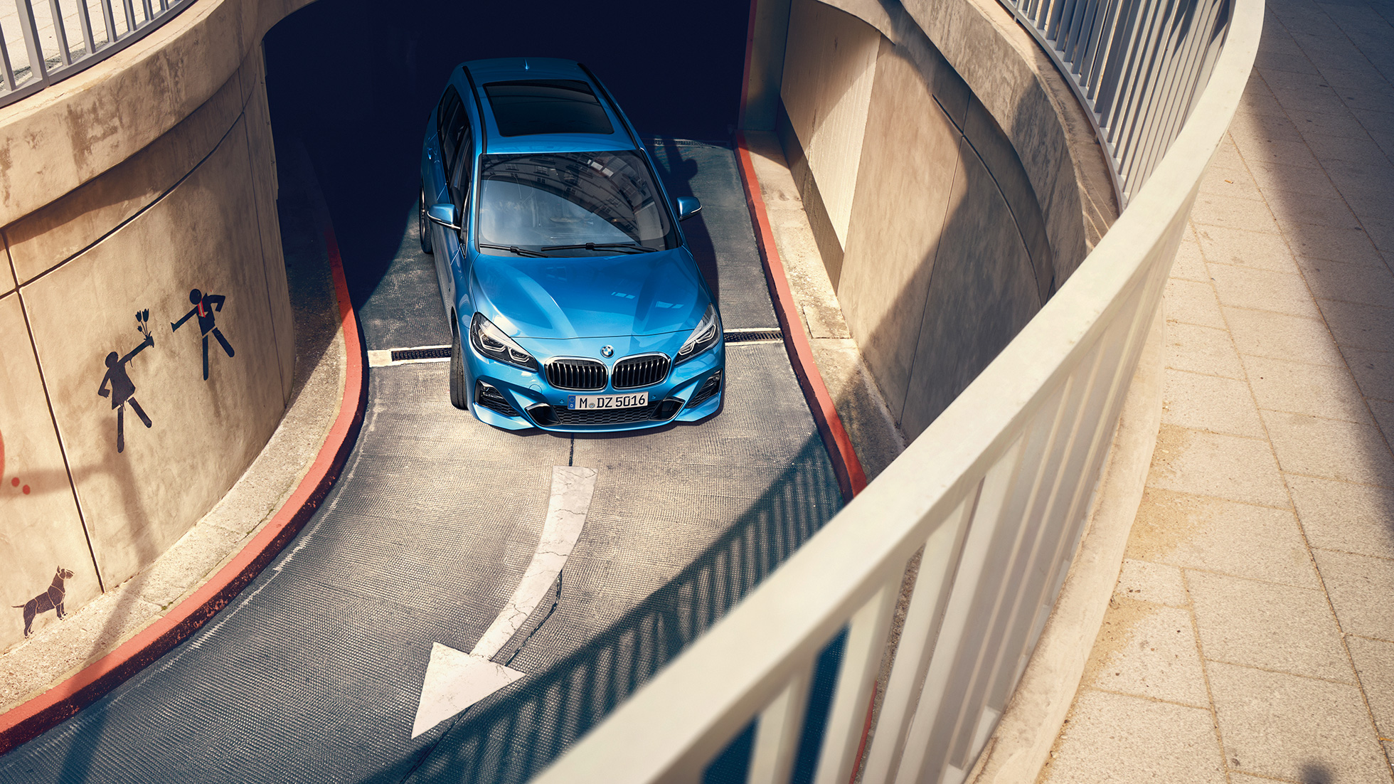 BMW radu 2 Gran Tourer jazdný záber na ceste v parkovacom dome BMW radu 2 Gran Tourer F46 2018 metalíza Estoril Blue jazdný záber v parkovacom dome z vtáčej perspektívy