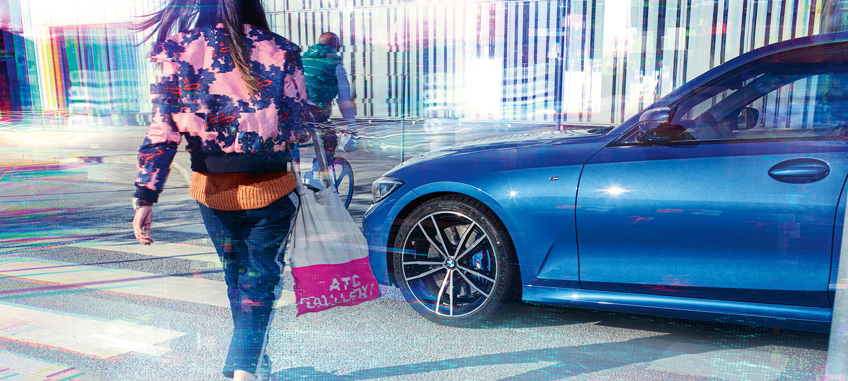 BMW radu 3 Sedan, bočný pohľad. Bočný pohľad na BMW radu 3 Sedan na asfalte v mestskom prostredí s okoloidúcimi.