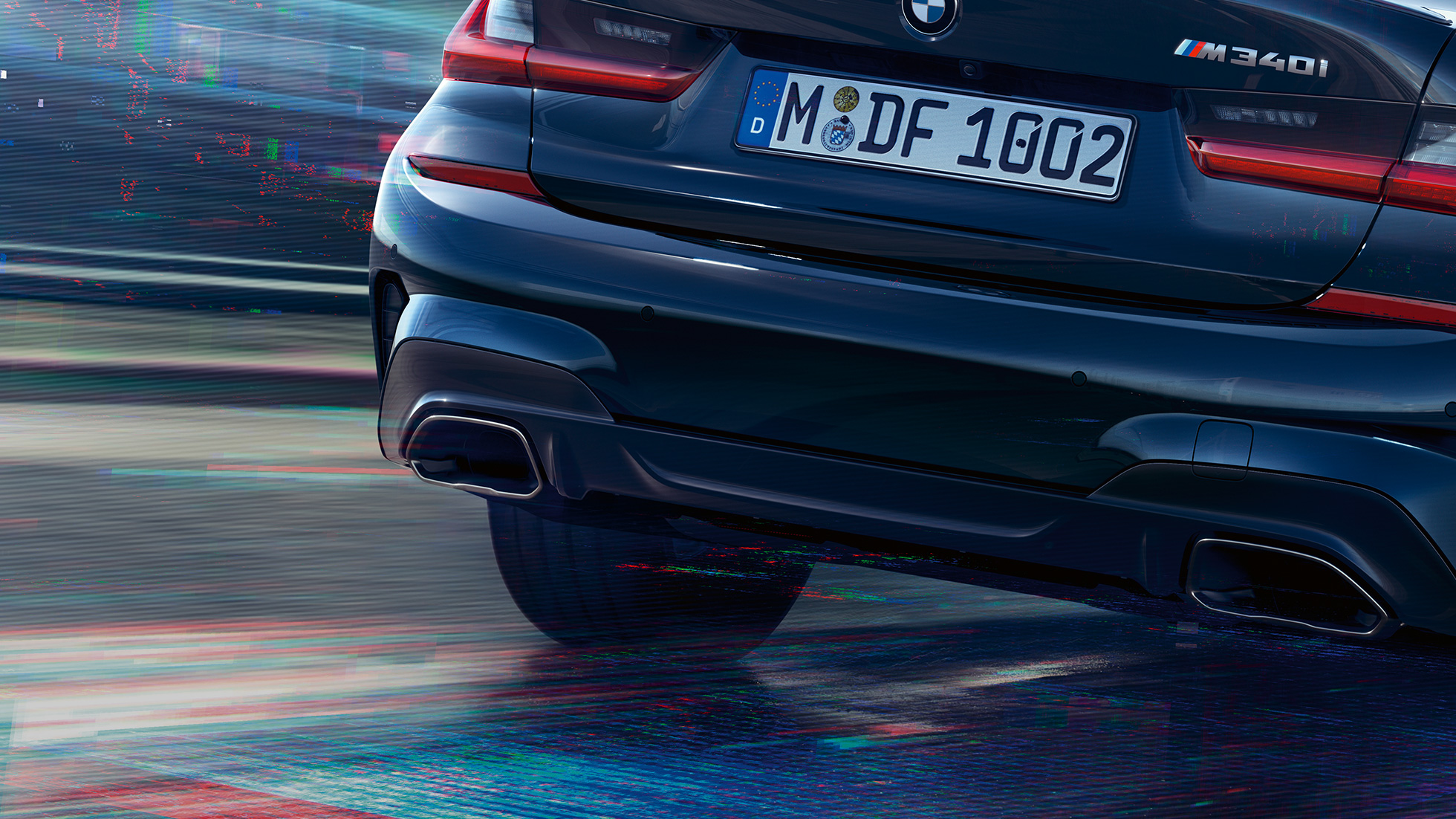 BMW radu 3 Sedan, M koncovky výfuku. Detailný záber na zadnú časť BMW radu 3 Sedan s M špecifickými koncovkami výfuku v metalíze Cerium Grey.