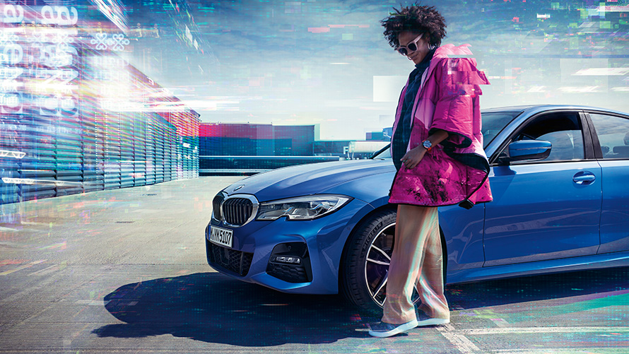BMW radu 3 Sedan (G20), metalíza Portimao Blue, predný záber BMW radu 3 Sedan (G20), metalíza Portimao Blue, predný záber na parkovisku s osobou v popredí