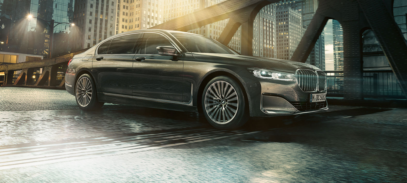 BMW radu 7 Sedan, bočný pohľad BMW radu 7 Sedan v bočnom pohľade s otvorenými dverami pred osvetleným hotelom