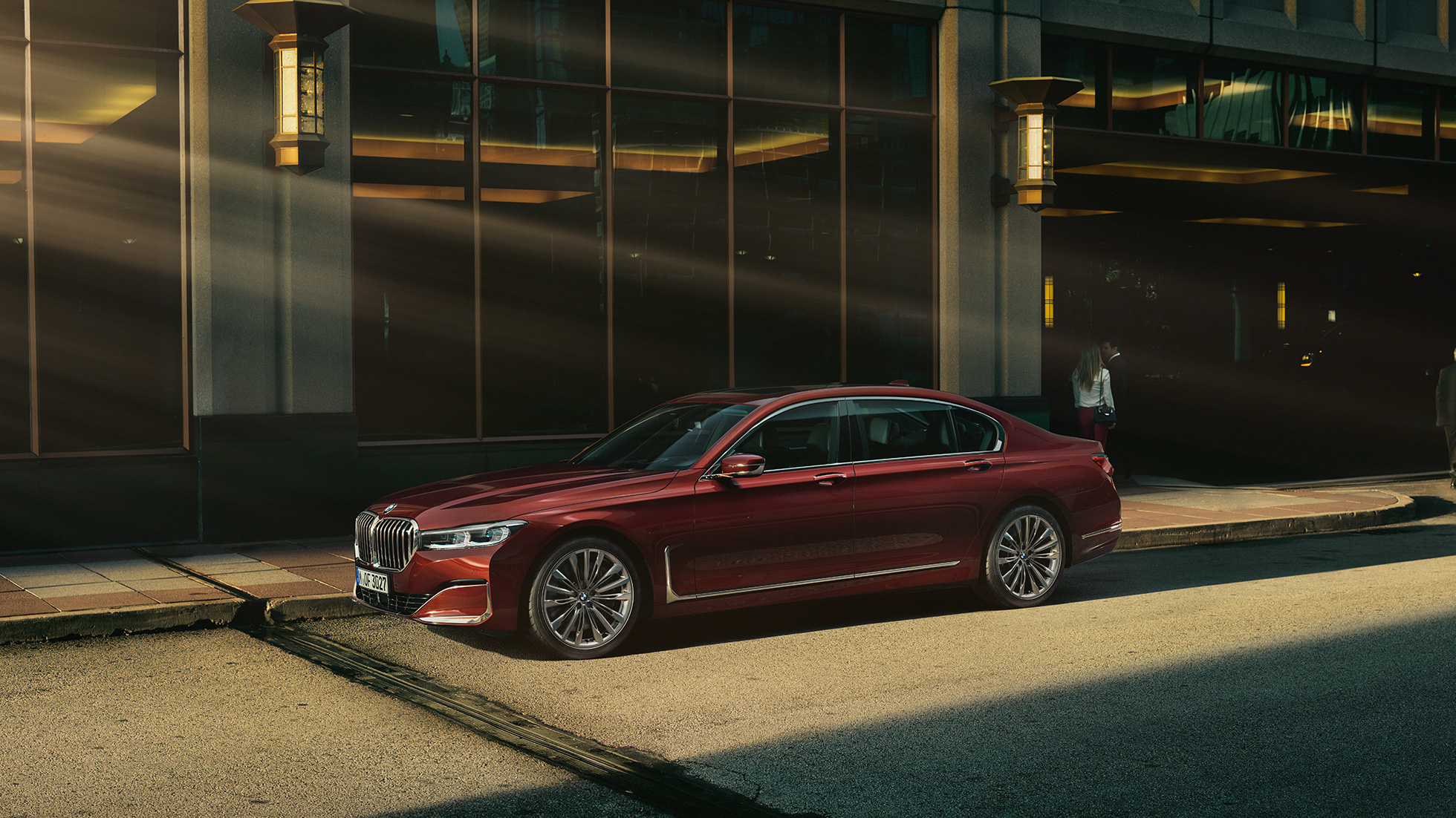 BMW Individual radu 7 Sedan, bočný pohľad BMW Individual radu 7 Sedan v červenej farbe z bočného pohľadu pred kulisami mesta