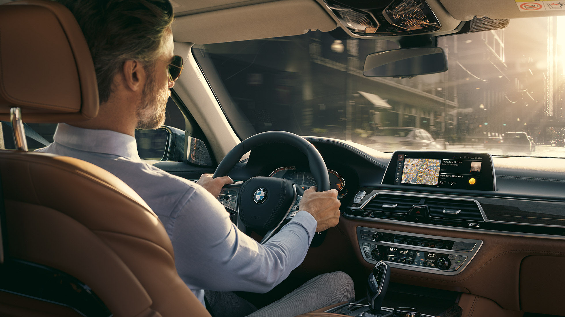 BMW radu 7 Sedan funkcie Connectivity BMW radu 7 Sedan: muž sediaci v BMW a používajúci funkcie Connectivity