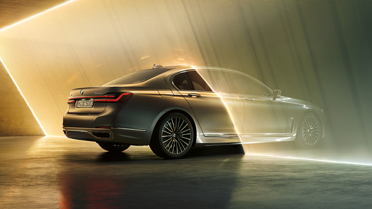 BMW radu 7 Sedan v sivej farbe Bernina BMW radu 7 Sedan v sivej farbe Bernina v trojštvrťovom zadnom pohľade obklopené lúčom svetla