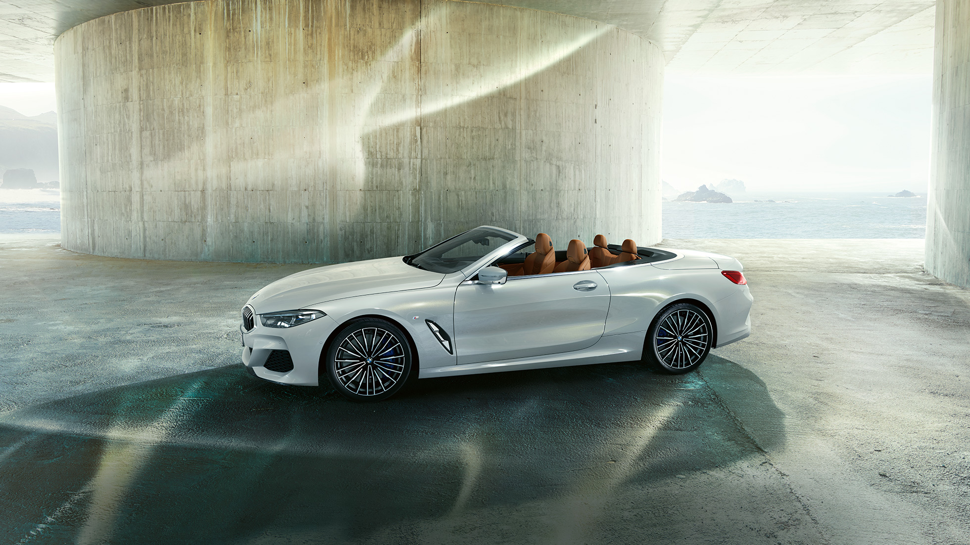 BMW M850i xDrive, metalíza Mineral White, bočný pohľad s otvorenou strechou. BMW M850i xDrive, metalíza Mineral White, bočný pohľad s otvorenou strechou.