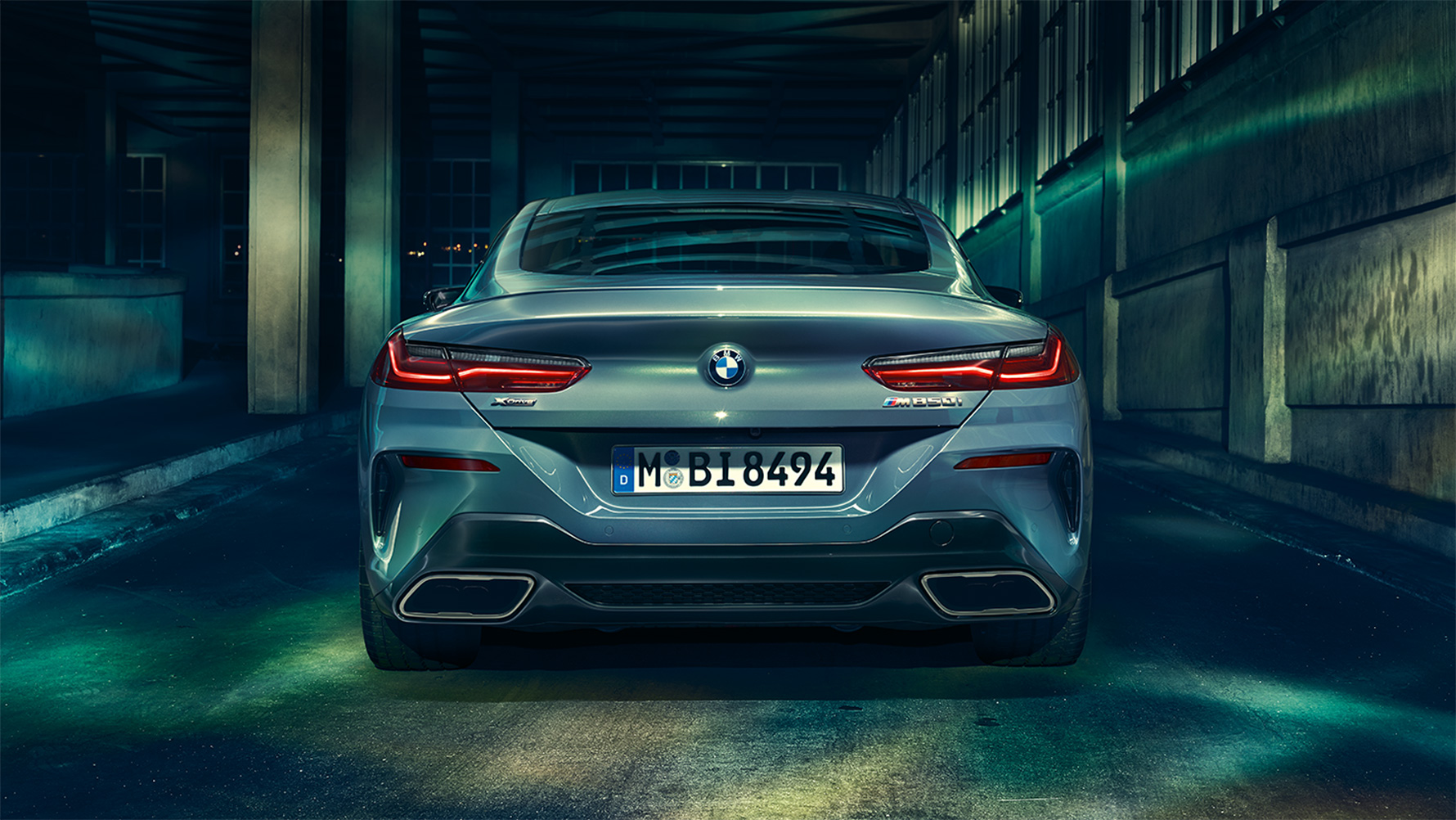 BMW radu 8 Coupé, zadný pohľad Zadný pohľad na BMW radu 8 Coupé v nočnom mestskom prostredí.