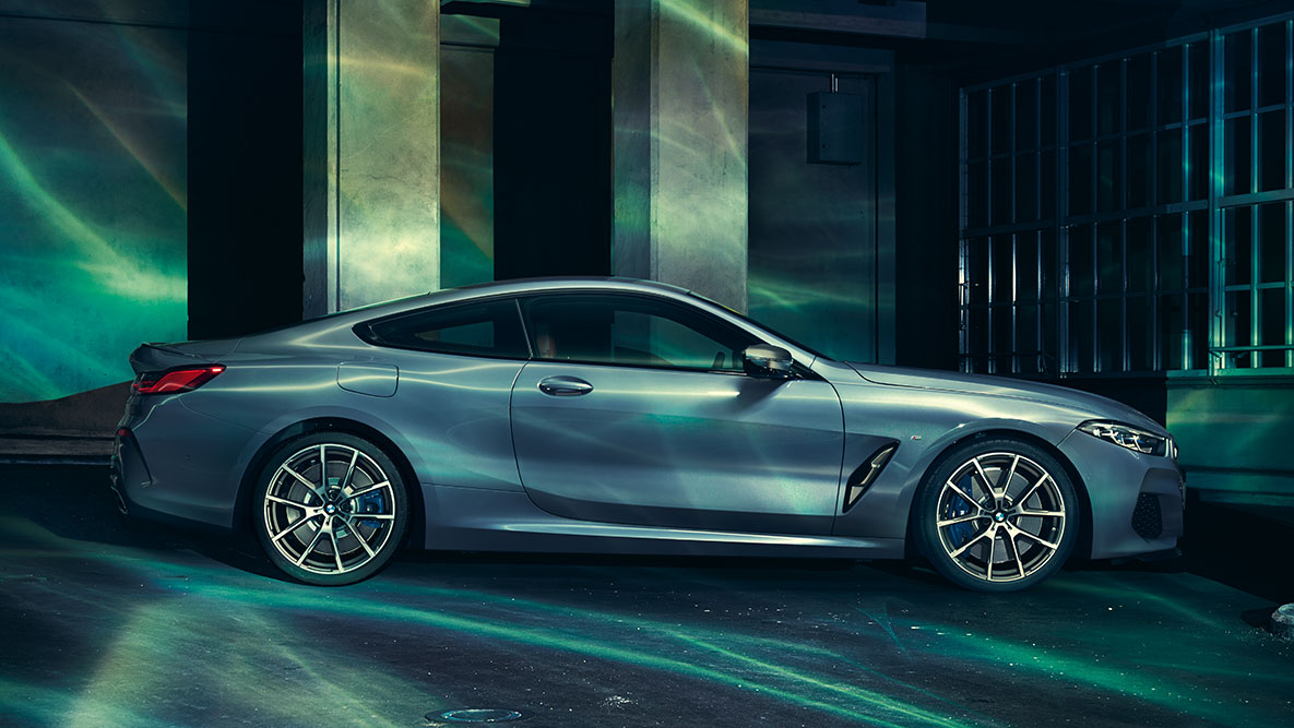 BMW radu 8 Coupé, bočný pohľad. A still shot of the BMW 8 Series Coupé from the side in an urban setting.