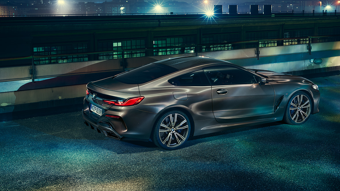 Statický bočný záber BMW radu 8 Coupé. Statický bočný záber BMW radu 8 Coupé s výbavou BMW Individual pred kulisou nočného mesta.