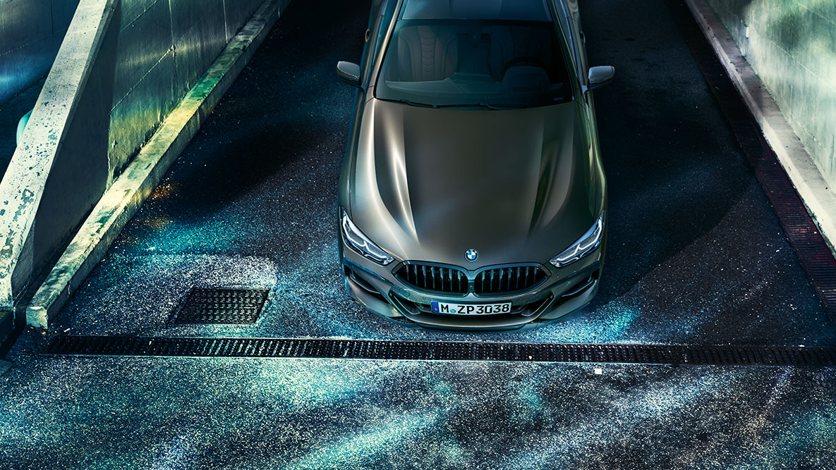 Predný statický záber BMW radu 8 Coupé. Predný statický záber BMW radu 8 Coupé s výbavou BMW Individual pred kulisou nočného mesta.