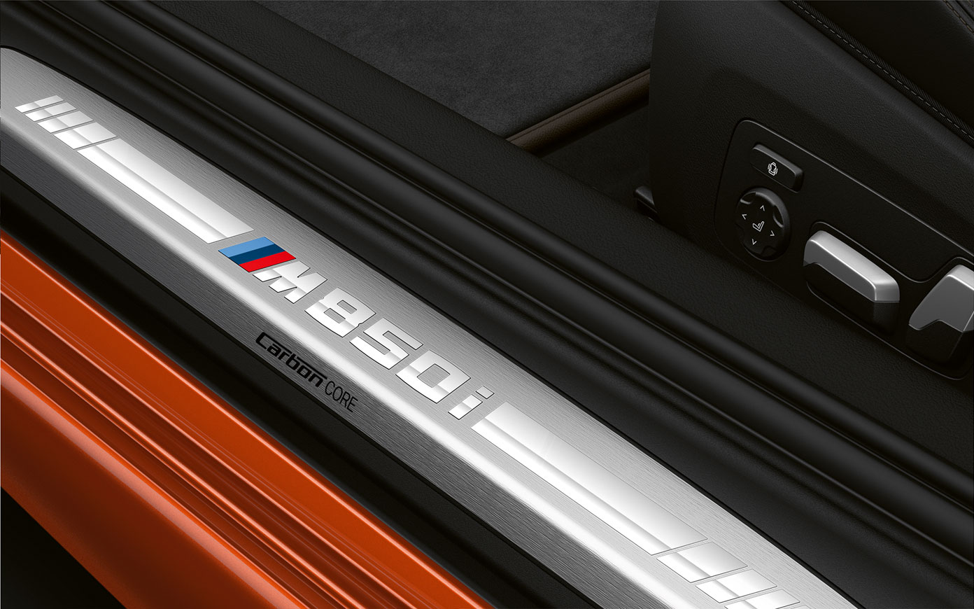 BMW radu 8 Coupé, prah dverí M850i. Detailný pohľad na prah dverí BMW radu 8 Coupé s logom M850i.