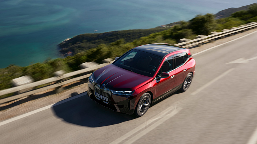 BMW iX i20 elektrické SUV BMW iX xDrive50 výkon BMW iX i20 2021 elektrické SUV BMW iX xDrive50 Aventurine Red na ulici výkon