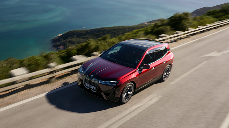 BMW iX i20 elektrické SUV BMW iX xDrive50 výkon BMW iX i20 2021 elektrické SUV BMW iX xDrive50 Aventurine Red na ulici výkon