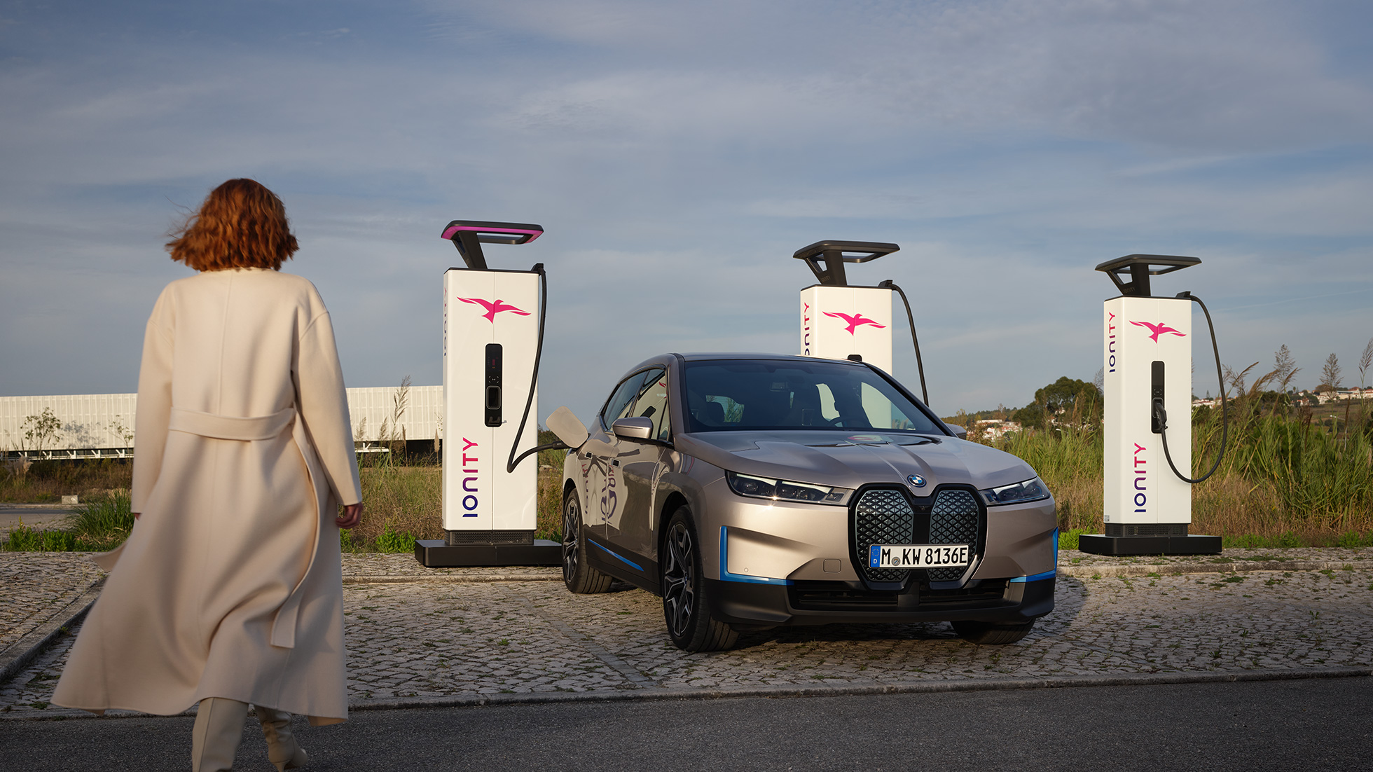 BMW iX predobočný pohľad na nabíjacej stanici BMW iX Cashmere Silver i20 predobočný pohľad na nabíjacej stanici