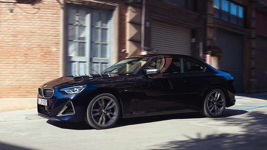Bočný pohľad BMW M240i xDrive Coupé G42 2021 BMW radu 2 Coupé G42 2021 metalíza Thundernight bočný pohľad statický pred skladiskom