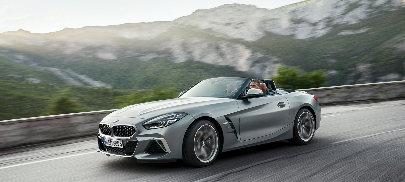 BMW Z4 M40i G29 počas jazdy s horami v pozadí BMW Z4 Roadster M40i G29 2019 Roadster BMW Individual metalíza Frozen Grey predobočný jazdný záber s horami v pozadí