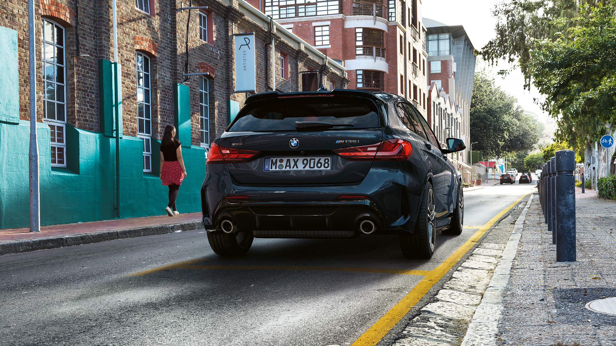 BMW M135i xDrive, zadný pohľad. BMW M135i xDrive v metalickej farbe Black Sapphire, zadný pohľad na odparkované vozidlo.