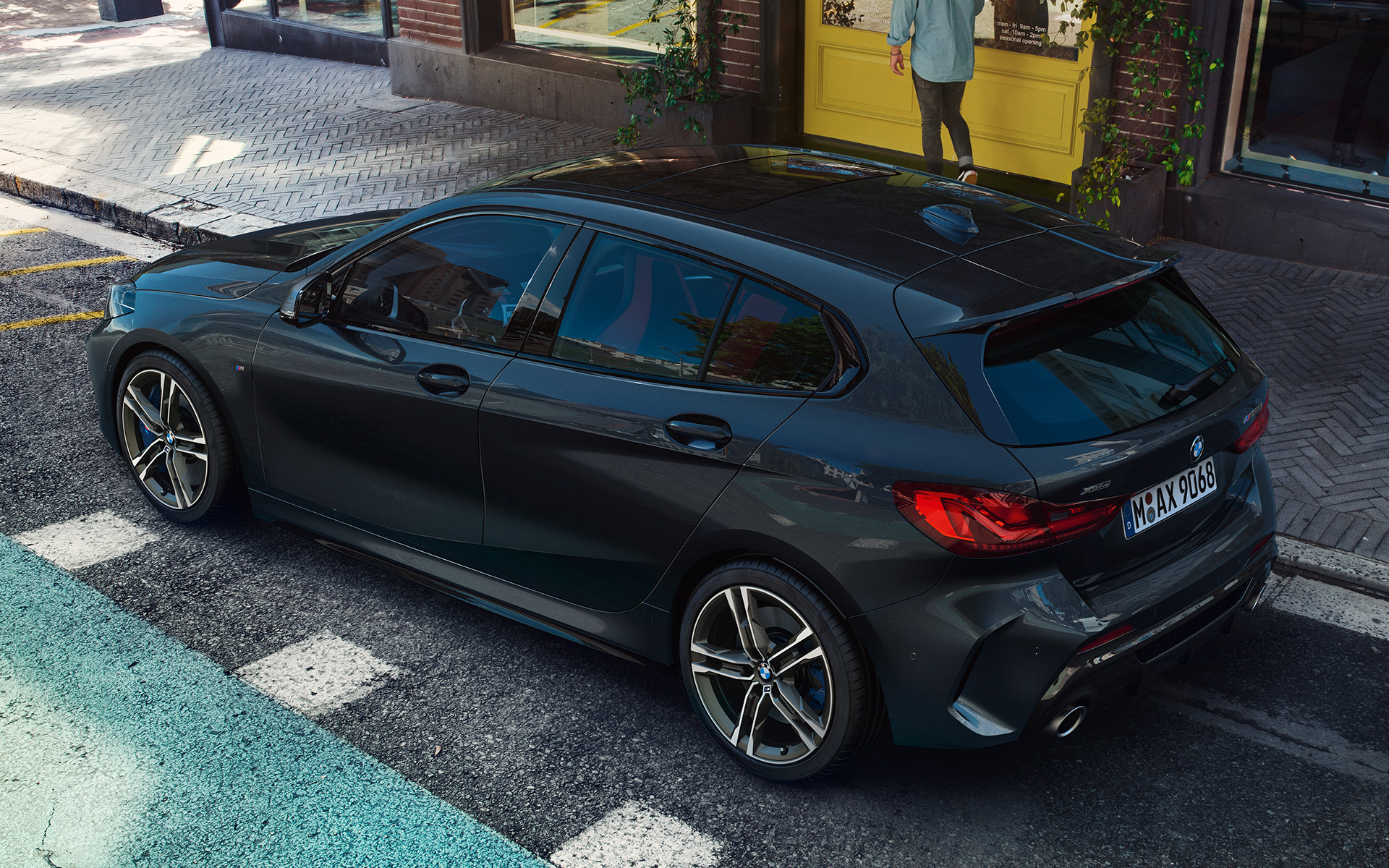 BMW M135i xDrive (F40) metalíza Black Sapphire, bočný pohľad zhora počas parkovania