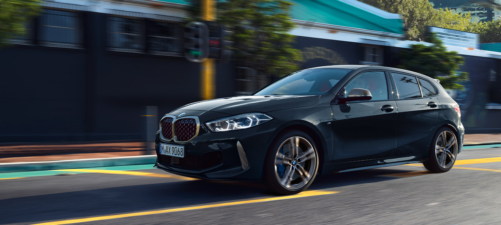 BMW radu 1 M135i xDrive (F40) metalíza Black Sapphire jazdný záber v mestskom prostredí