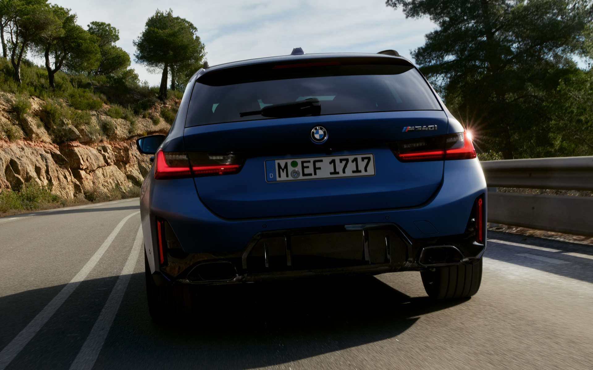 BMW M340i xDrive Touring G21 zadný pohľad jazdný na ceste BMW M340i xDrive Touring G21 Frozen Tanzanite Blue zadný pohľad jazdný na ceste