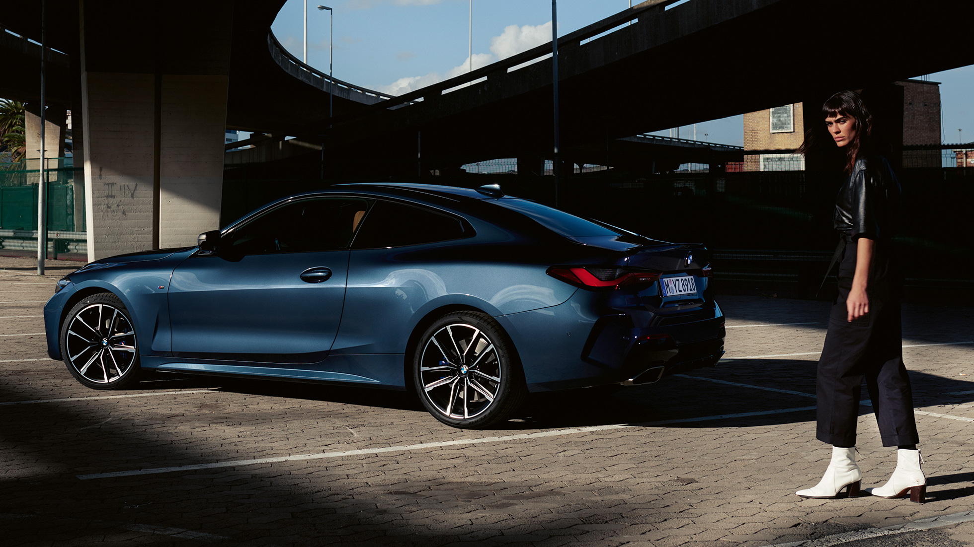 Zadobočný pohľad s modelkou BMW M440i xDrive Coupé G22 2020 BMW M440i xDrive Coupé metalíza Arctic Race Blue G22 2020 zadobočný pohľad s modelkou