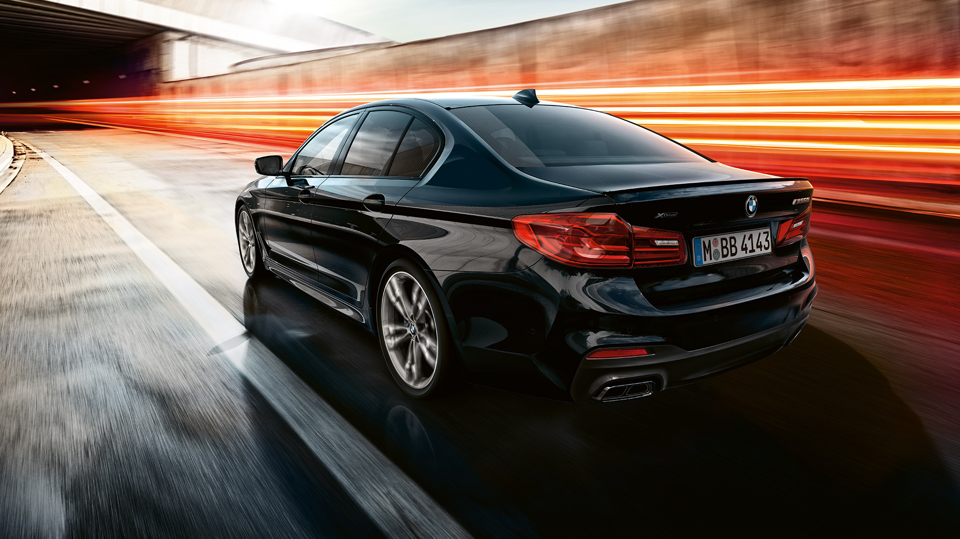 Jazdná dynamika. BMW M550i a BMW M550d, trojštvrťový zadný pohľad počas jazdy.