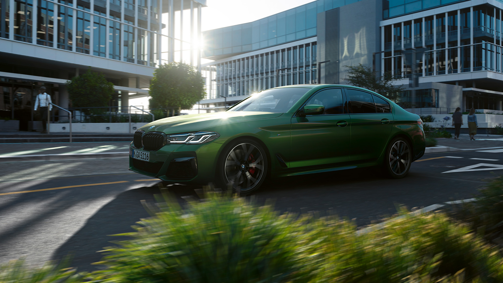 BMW M550i xDrive Sedan G30 LCI Facelift 2020 bočný jazdný pohľad BMW M550i xDrive Sedan G30 LCI Facelift 2020 BMW Individual metalíza Verde Ermes bočný jazdný pohľad v meste