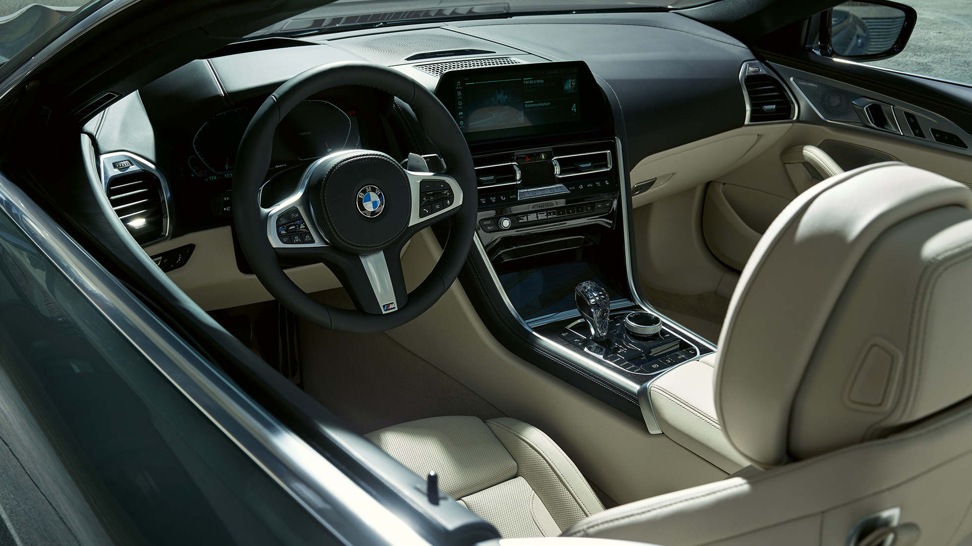 BMW M850i xDrive Cabrio, kokpit. BMW M850i xDrive Cabrio v metalickej farbe Dravit Grey s otvorenou strechou, kokpit s M koženým volantom.