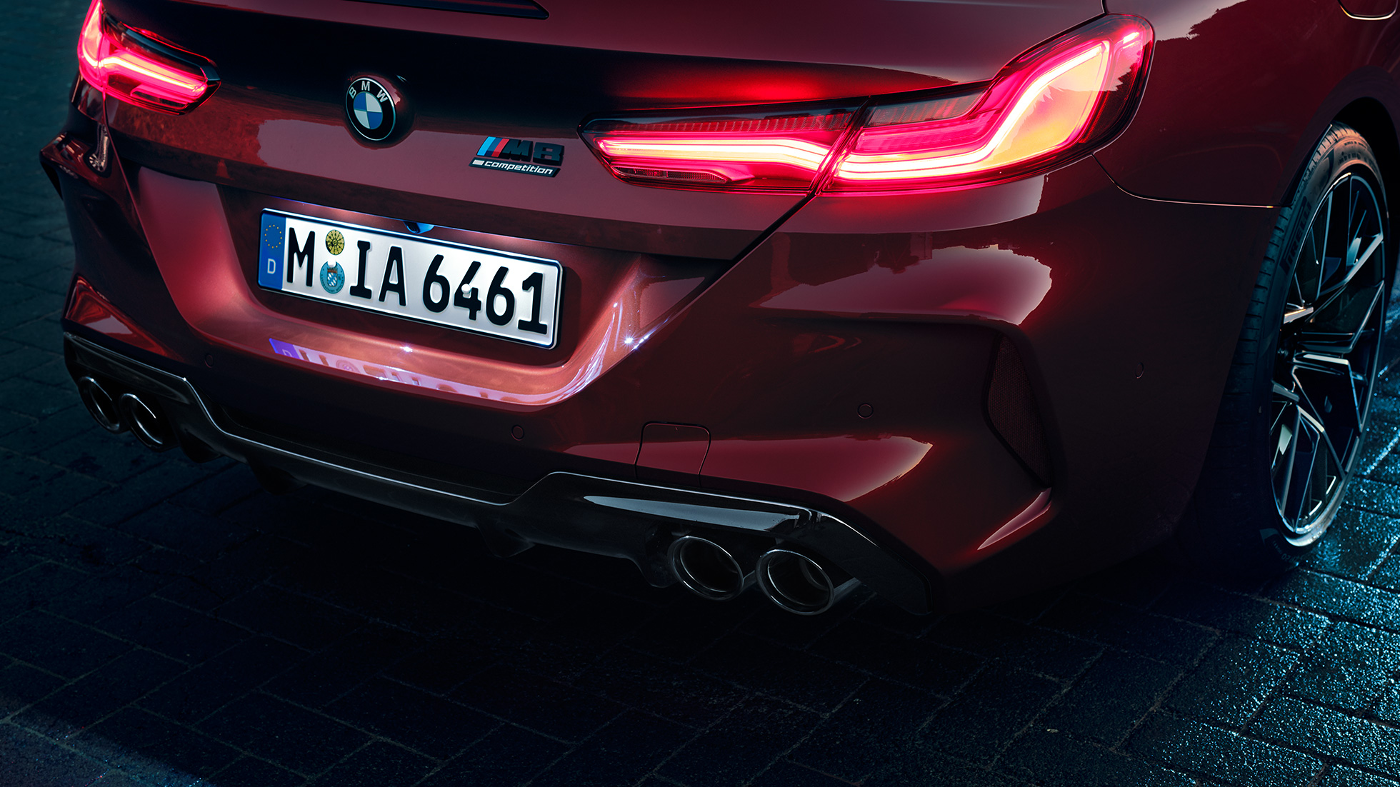 BMW M8 Competition Cabrio, detailný pohľad na zadnú časť. BMW M8 Competition Cabrio v metalickej farbe Motegi Red, detailný pohľad na zadnú časť s LED zadnými svetlami a znakom M8 Competiton.