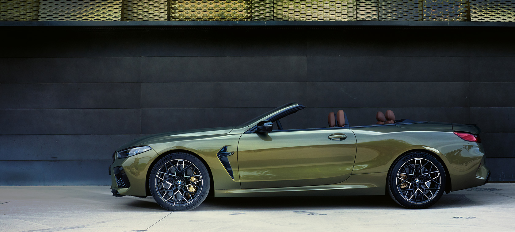 BMW M8 Competition Cabrio F91 LCI Facelift 2022 bočný pohľad statický BMW M8 Competition Cabrio F91 LCI Facelift 2022 BMW Individual metalíza Brass bočný pohľad statický s otvorenými dverami a modelkou