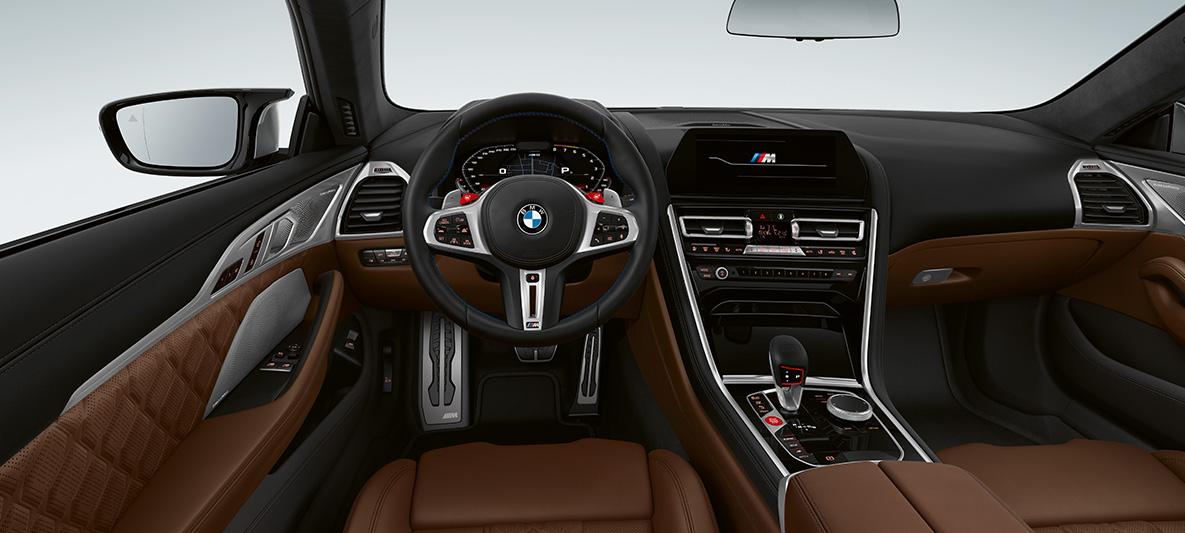BMW M8 Coupé, kokpit. BMW M8 Coupé, kokpit s M koženým volantom s tlačidlami M1/M2 v červenej farbe.