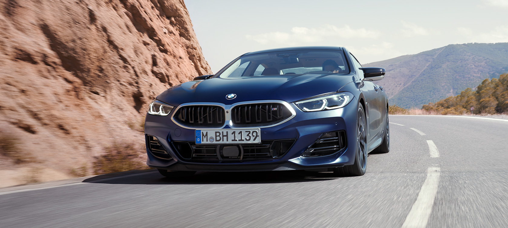 Predobočný pohľad jazdný BMW M850i xDrive Gran Coupé G16 LCI Facelift 2022 BMW M850i xDrive Gran Coupé G16 LCI Facelift 2022 BMW Individual metalíza Frozen Tanzanite Blue predobočný pohľad jazda v zákrute