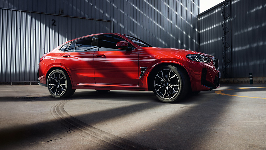 BMW X4 M F98 LCI Facelift 2021 metalíza Toronto Red bočný pohľad pred továrenskou halou