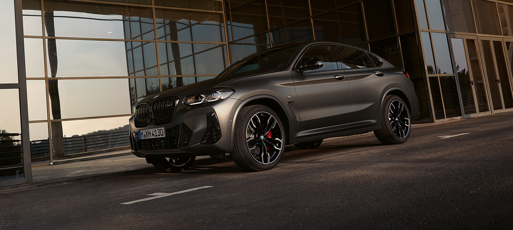 Predobočný pohľad BMW X4 M40i G02 LCI 2021 BMW X4 M40i G02 LCI 2021 Facelift predobočný pohľad pred sklenenou fasádou