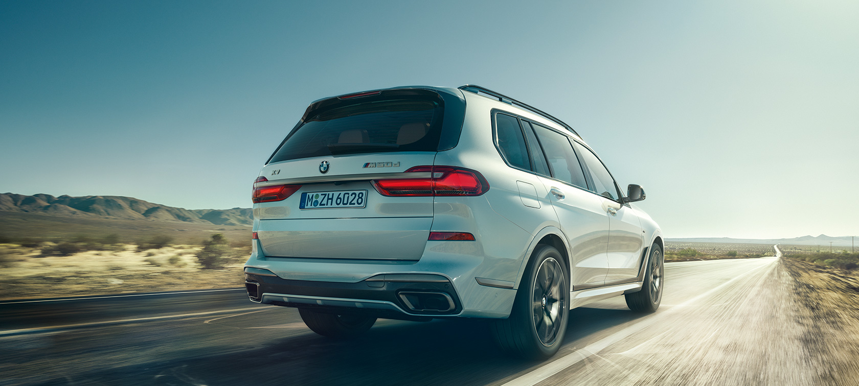 BMW X7 M50i, zadný pohľad BMW X7 M50i vo farbe Mineral White, jazda na prázdnej diaľnici, pohľad zozadu, G07, 2019