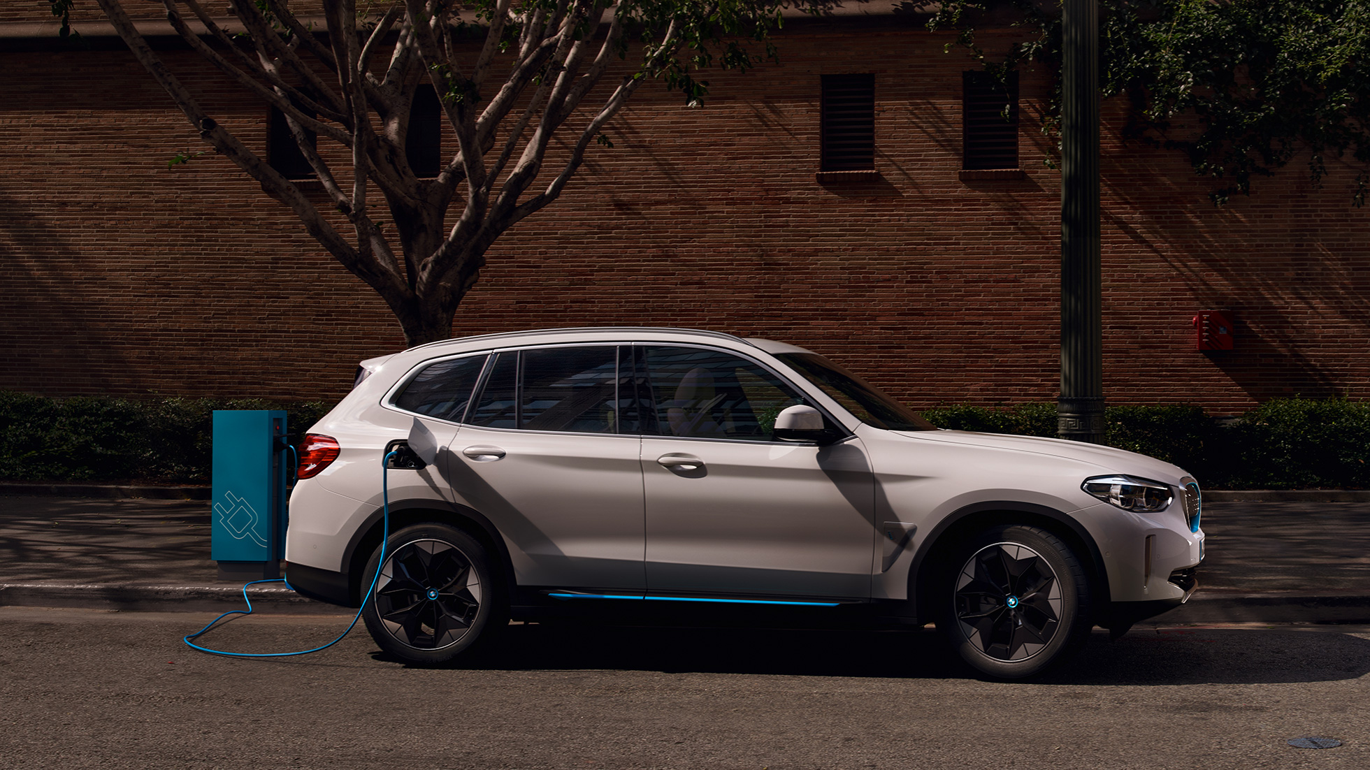 Vysokovýkonné nabíjanie BMW iX3 G08 bočný pohľad na verejnej nabíjacej stanici Vysokovýkonné nabíjanie BMW iX3 G08 2020 metalíza Mineral White bočný pohľad na verejnej nabíjacej stanici
