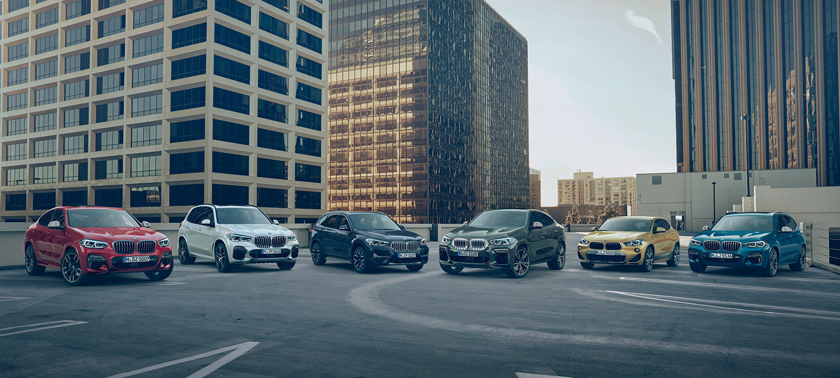 Vozidlá BMW X na parkovisku pred budovami Modely BMW X Vozidlá BMW X na parkovisku pred budovami