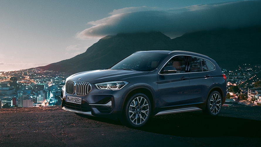 BMW X1 F48 druhá generácia bočný pohľad statický v pozadí s mestom Modely BMW X BMW X1 F48 druhá generácia bočný pohľad statický v pozadí s mestom