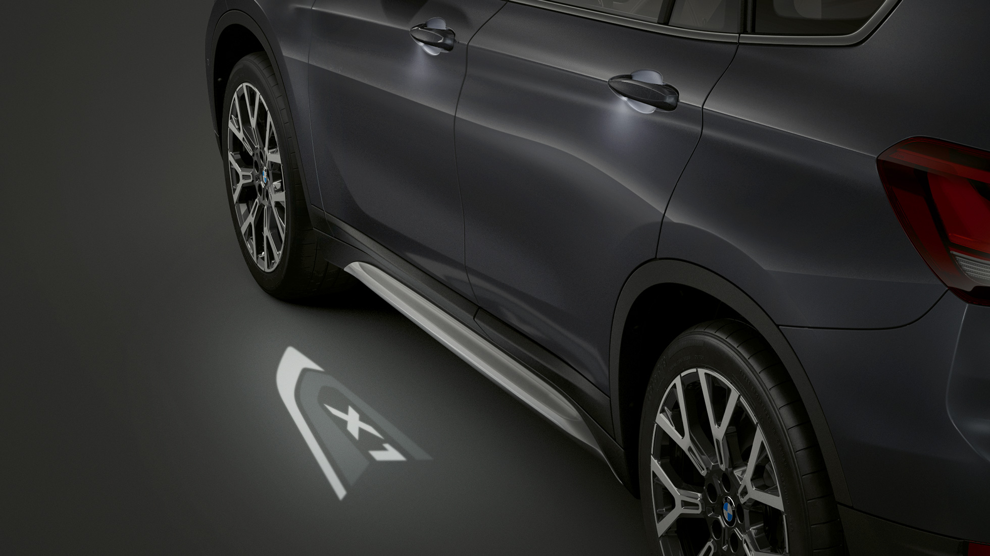 BMW X1, LED projekcia „X1”. BMW X1, bočný pohľad so zameraním na LED projekciu „X1”.