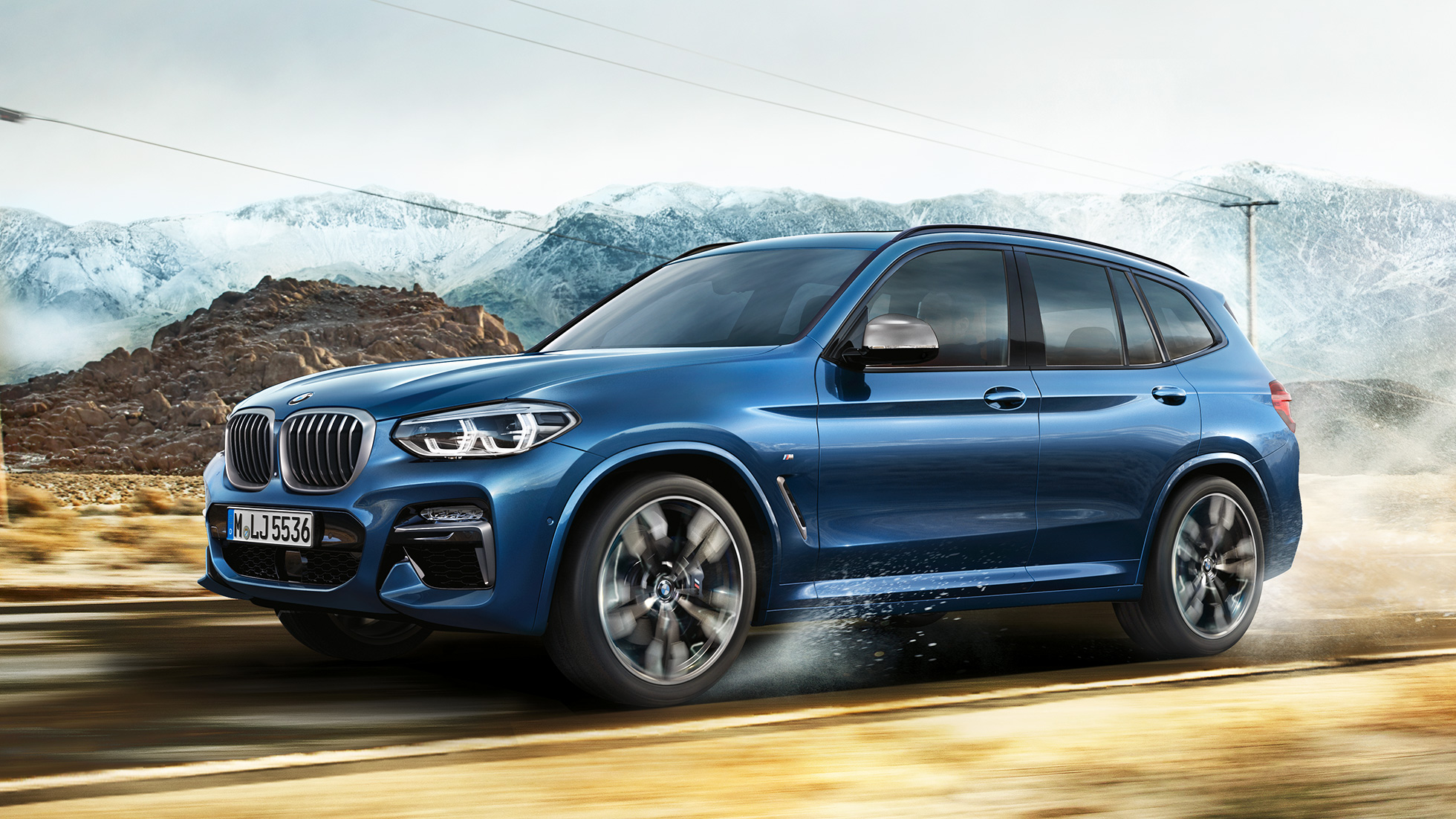 BMW X3 M40i, polovičná snímka disku kolesa a blatníka pred horskou scenériou BMW X3 M40i, polovičná snímka disku kolesa a blatníka pred horskou scenériou